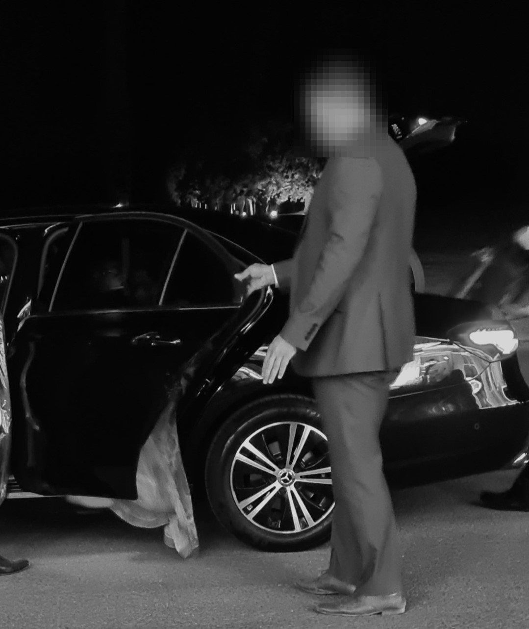 Private chauffeur opening car door